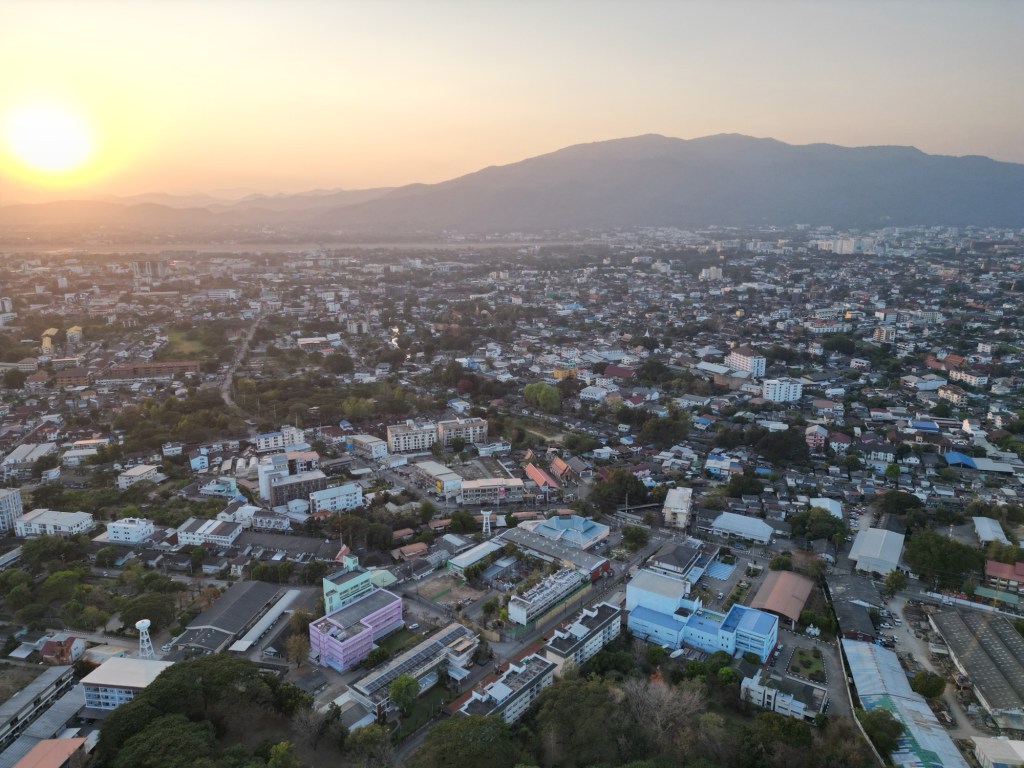 Aerial view of Chiang Mai city at sunset with mountains in the background, northern Thailand