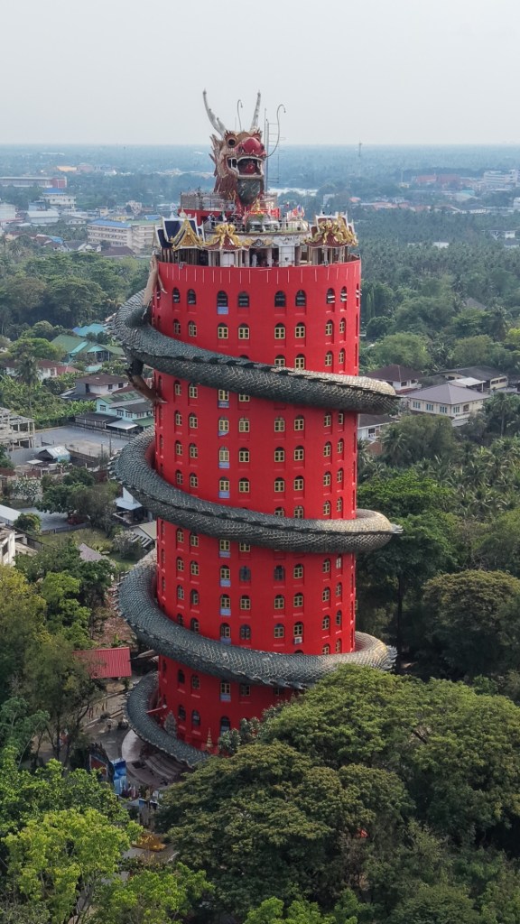 Wat Samphran Dragon Temple in Thailand with a large dragon wrapped around a tall red tower