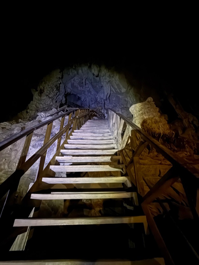 Steep wooden staircase inside Tham Lod Cave that visitors must climb during the cave tour near Pai, Thailand.