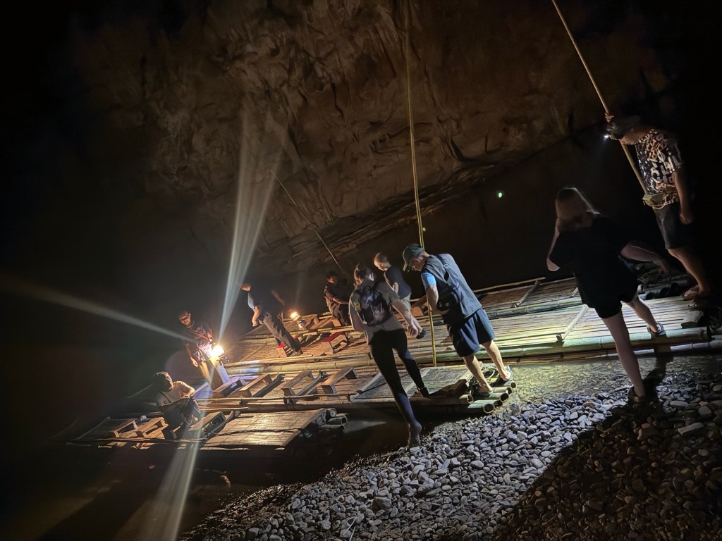 Visitors boarding bamboo rafts inside Tham Lod Cave for the underground river journey near Pai, Thailand.