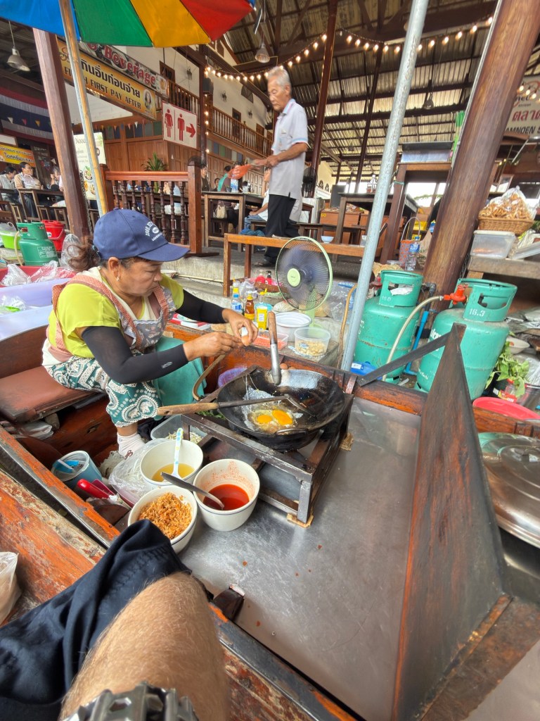 Vendor cooking pad Thai in a boat at Damnoen Saduak Floating Market in Thailand
