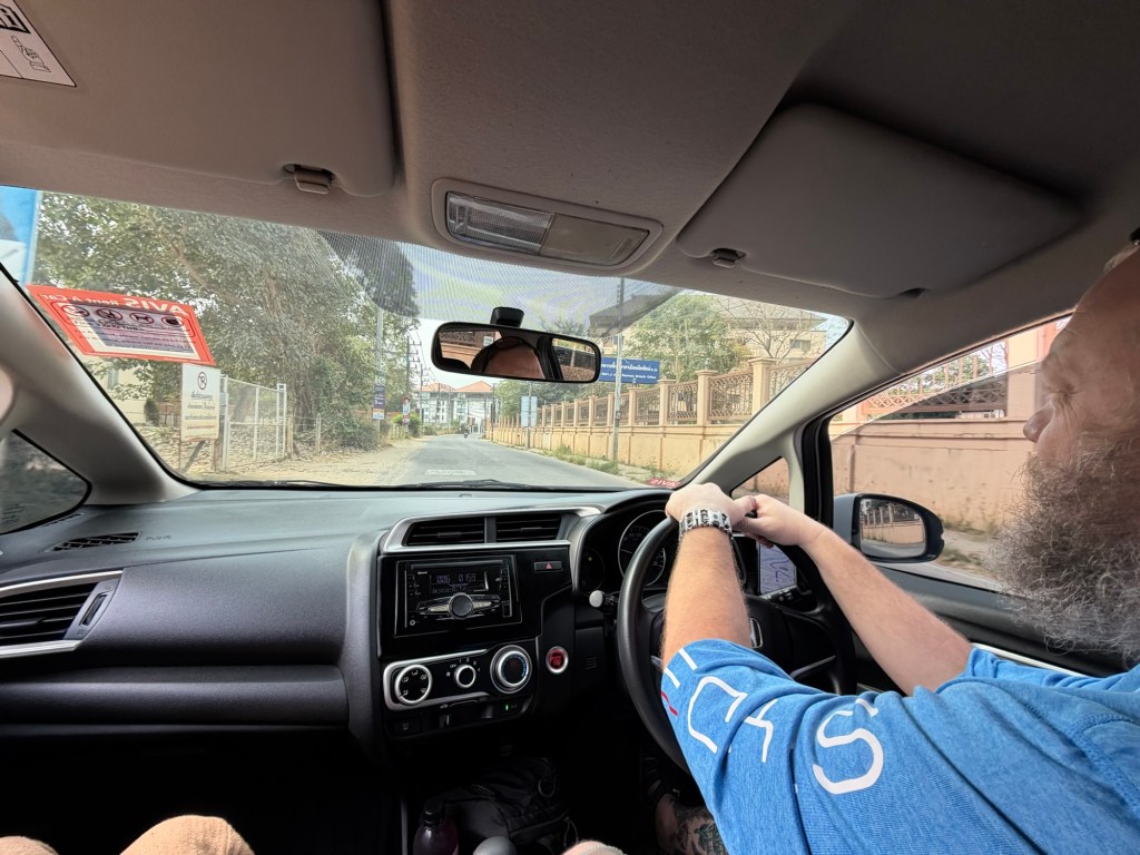 View from inside a car driving through Chiang Mai, Thailand, showing local roads and surroundings