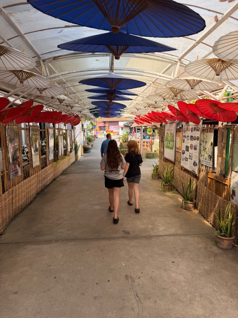 Colorful handmade umbrellas hanging overhead at the Bo Sang Umbrella Village near Chiang Mai