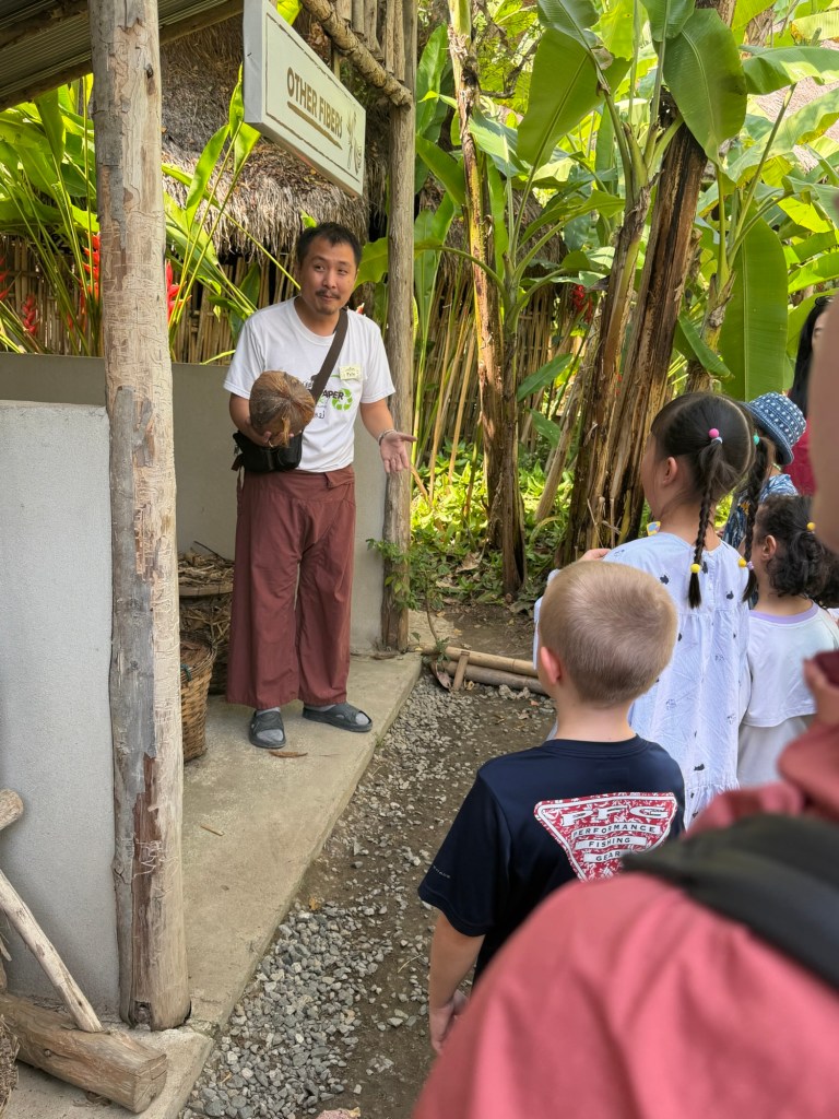Guide demonstrating the papermaking process to visiting children at Poopoopaper Park in Chiang Mai Thailand.