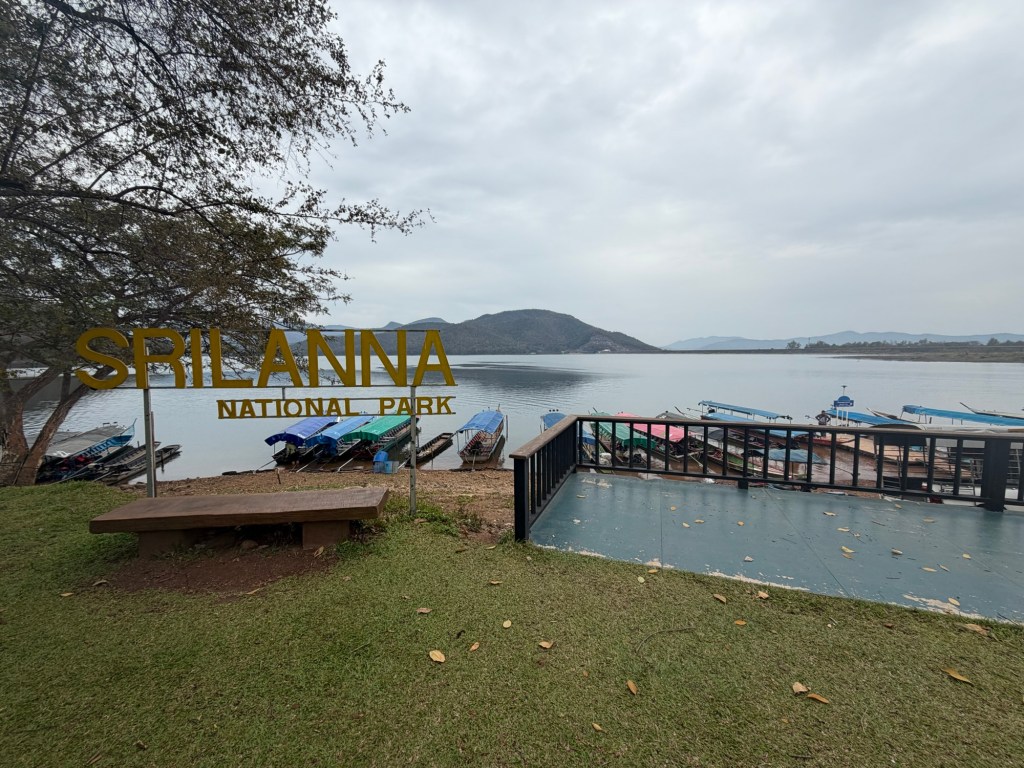 Sri Lanna National Park sign overlooking Mae Ngat Dam lake with longtail boats and mountains in Chiang Mai