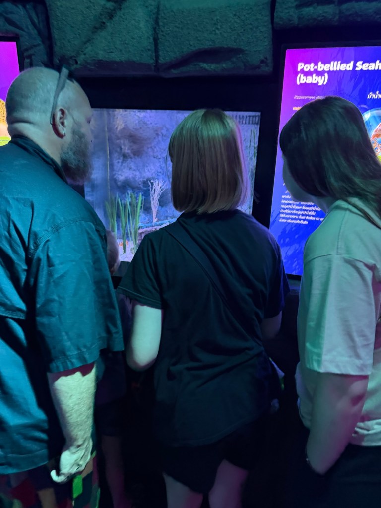 Family learning together at interactive exhibit while traveling in Thailand
