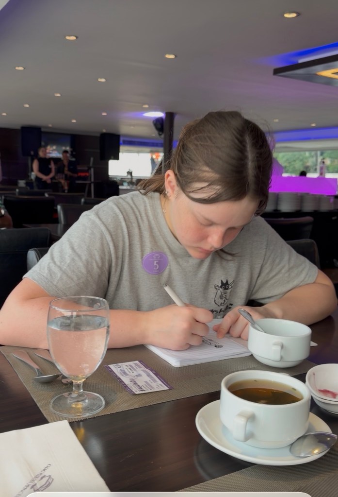 Child drawing in notebook while traveling in Thailand worldschooling lifestyle
