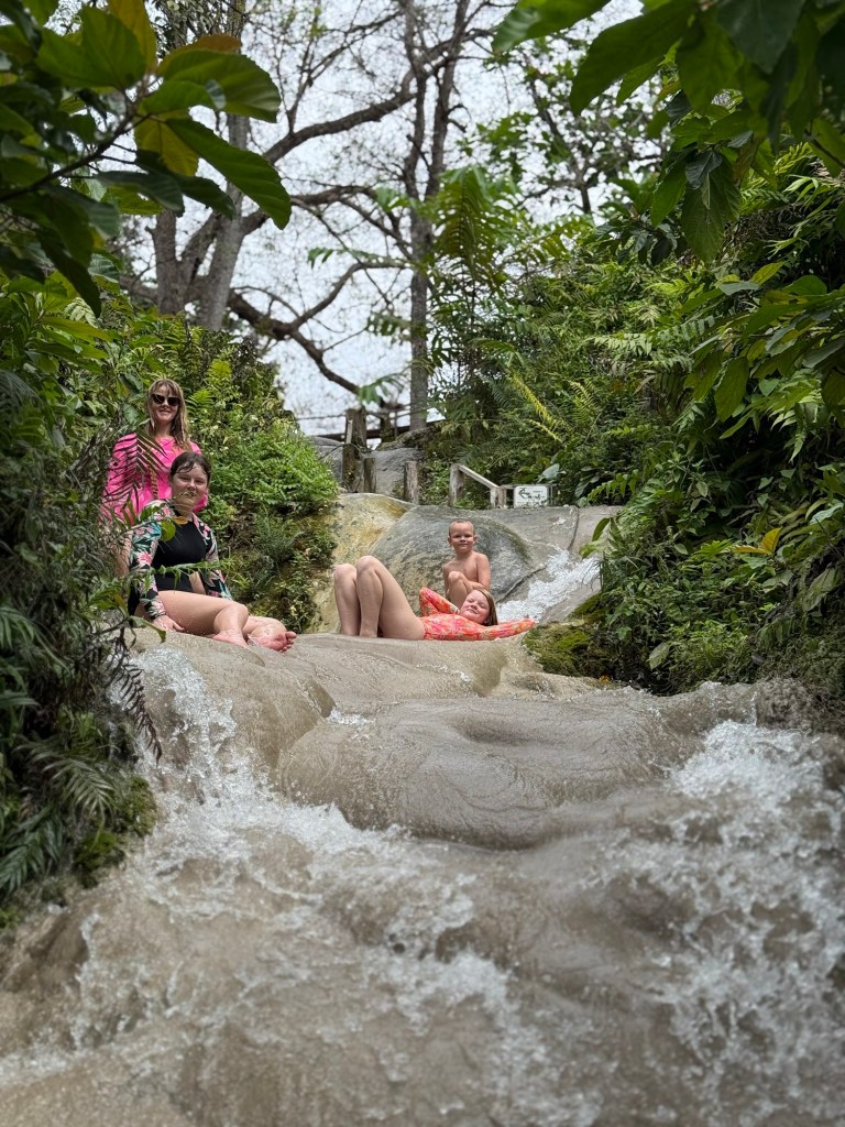 Family sliding and climbing Bua Tong Sticky Waterfalls in Chiang Mai Thailand