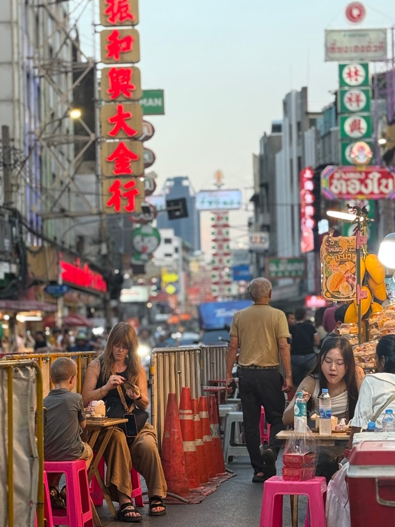 Street food scene in Bangkok with kids experiencing busy city atmosphere
