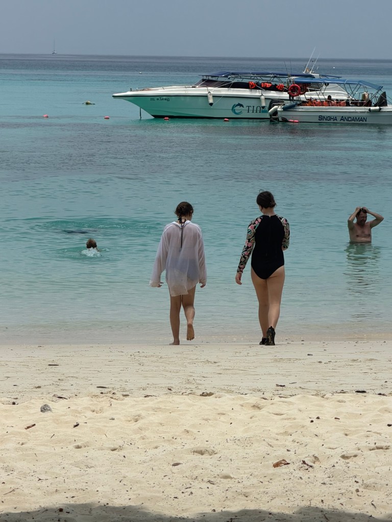 Children walking into the ocean during a snorkeling trip near Koh Lanta, Thailand.